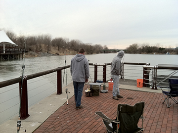 (From left) Chris West and Bill Markle were packed in tight to the corner in hopes of catching a carp swimming out of the stream that joins the Inner Harbor.